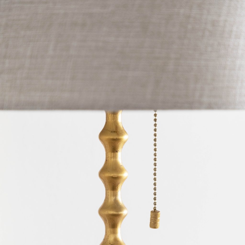 Gold cast metal lamp with pale fabric shade