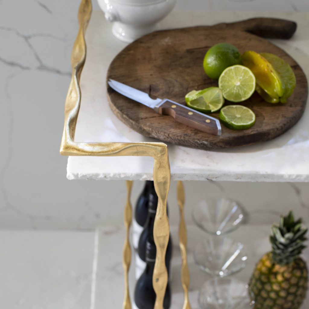 gilded bar cart with white marble and sliced limes